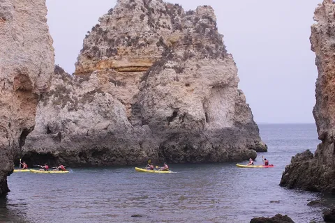 Kayakers among the golden sea cliffs at Ponta da Piedade, Lagos, in the Algarve, Portugal