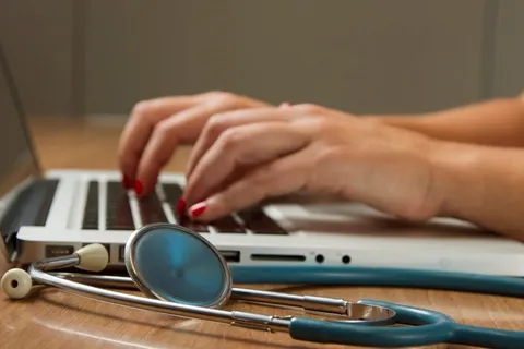 Stethoscope next to a laptop — comparing health insurance for expats in Portugal